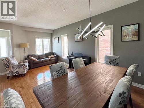 Dining area with wood finished floors, a textured ceiling, and a chandelier - 2429 Whitehorn Drive, Burlington, ON - Indoor