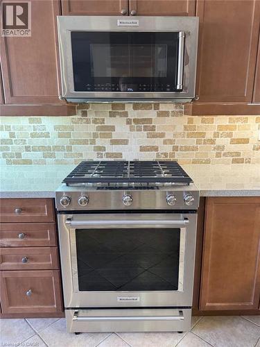 Kitchen featuring stainless steel appliances, light countertops, light tile patterned flooring, and tasteful backsplash - 2429 Whitehorn Drive, Burlington, ON - Indoor Photo Showing Kitchen