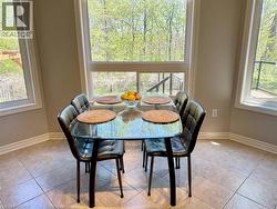 Dining room with plenty of natural light and light tile patterned floors - 