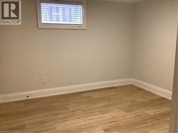 Basement with light wood-type flooring and baseboards - 