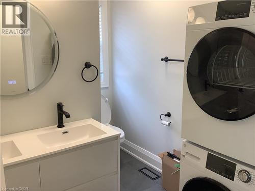Bathroom with double vanity and stacked washer / drying machine - 229 West 18Th Street, Hamilton, ON - Indoor Photo Showing Laundry Room