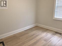 Unfurnished room featuring light wood-style floors and baseboards - 