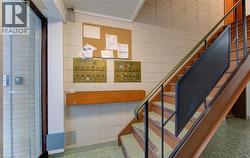 Stairs featuring mail area, speckled floor, and tile walls - 
