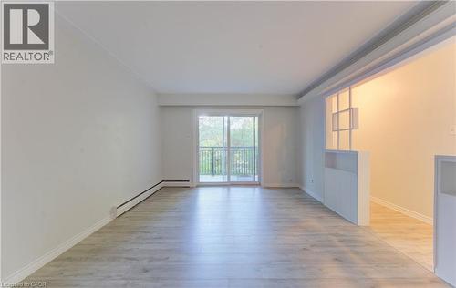 Unfurnished room with light wood-style flooring and baseboard heating - 50 Gordon Avenue, Kitchener, ON - Indoor Photo Showing Other Room