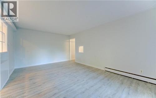 Spare room featuring wood finished floors and a baseboard radiator - 50 Gordon Avenue, Kitchener, ON - Indoor Photo Showing Other Room
