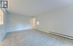 Spare room featuring wood finished floors and a baseboard radiator - 