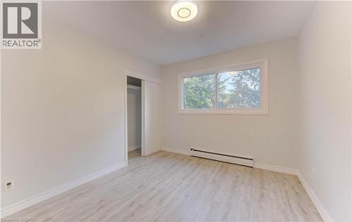 Unfurnished bedroom with light wood finished floors, a baseboard radiator, and a closet - 50 Gordon Avenue, Kitchener, ON - Indoor Photo Showing Other Room