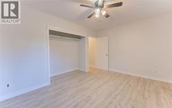 Unfurnished bedroom featuring light wood-style floors, a ceiling fan, and a closet - 