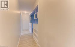 Hall with light wood-style flooring and baseboards - 