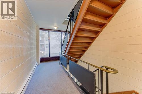 Hall featuring stairway, a baseboard heating unit, carpet flooring, and concrete block wall - 50 Gordon Avenue, Kitchener, ON - Indoor Photo Showing Other Room