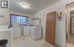 Shared laundry room featuring washer and dryer and light tile patterned flooring - 