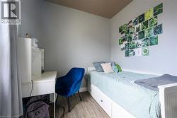 Bedroom featuring light wood-type flooring and baseboards - 