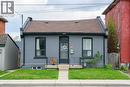 View of front facade featuring brick siding, a shingled roof, a front yard, and a gate - 129 Dundurn Street N, Hamilton, ON  - Outdoor 
