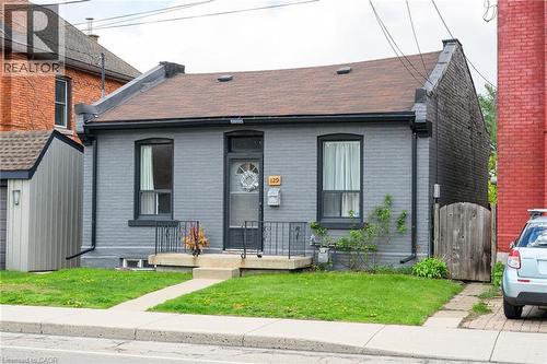 View of front of house with brick siding, a gate, a shingled roof, and a front yard - 129 Dundurn Street N, Hamilton, ON - Outdoor
