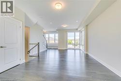 Empty room featuring light wood finished floors, recessed lighting, and stairway - 