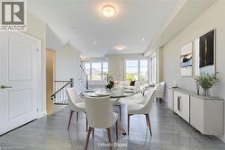 Dining room featuring light wood finished floors, recessed lighting, and stairs - 