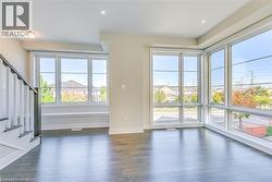 Unfurnished living room with plenty of natural light, dark wood-type flooring, stairs, and recessed lighting - 