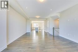 Unfurnished living room with light wood-style flooring and baseboards - 