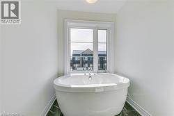 Full bath featuring baseboards and a freestanding tub - 