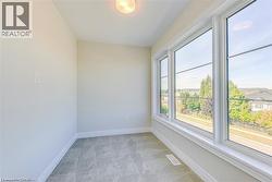 Spare room featuring light carpet and baseboards - 