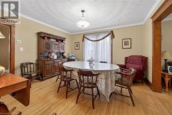 Dining room with crown molding, light wood-type flooring, and a textured ceiling - 