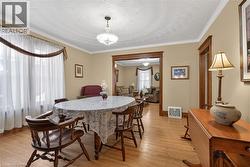 Dining area featuring light wood-style floors and crown molding - 