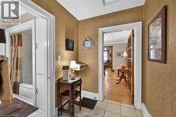 Hall with light tile patterned flooring and baseboards - 