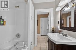Full bathroom featuring vanity, shower / tub combination, and light tile patterned flooring - 