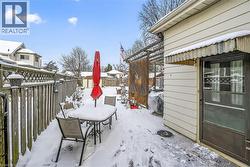 Snow covered patio with a fenced backyard and a grill - 