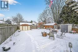 Yard layered in snow with a storage shed and a fenced backyard - 