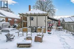 Snow covered rear of property with outdoor dining space and a chimney - 