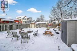 Snowy yard with a storage shed, a fenced backyard, and a residential view - 