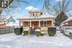 Bungalow featuring brick siding and covered porch - 