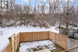 Yard covered in snow featuring a fenced backyard and a wooden deck - 