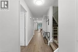 Corridor featuring stairway, light wood-style flooring, and a textured ceiling - 