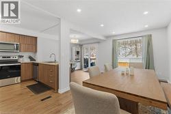 Dining area with light wood-style flooring and recessed lighting - 