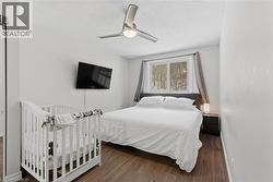 Bedroom featuring ceiling fan, dark wood-style flooring, and a textured ceiling - 