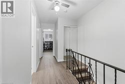 Corridor with an upstairs landing and light wood-style flooring - 