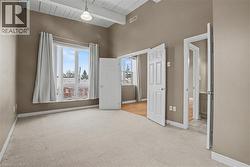 Primary bedroom with light coloured carpet and large window allowing a lot of light to flow into the room - 