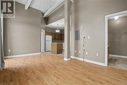 Lliving room with high vaulted ceiling, light natural coloured flooring, electric panel, and a wood ceiling with exposed beams - 
