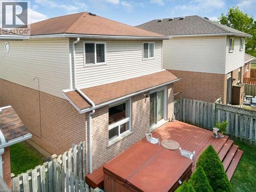 Rear view of property featuring a fenced backyard, a hot tub, brick siding, and a deck - 75 Marisa Street, Kitchener, ON - Outdoor With Exterior