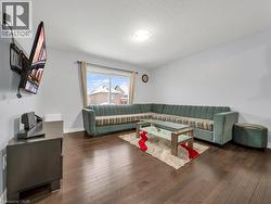 Living room featuring a textured ceiling and dark wood-style flooring - 