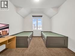 Unfurnished bedroom featuring vaulted ceiling and carpet floors - 