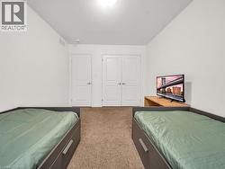 Bedroom with a textured ceiling, light carpet, and a closet - 