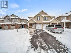 View of front facade featuring a garage, driveway, and brick siding - 