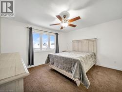 Bedroom featuring ceiling fan and dark carpet - 