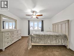 Bedroom with dark colored carpet and a ceiling fan - 