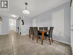 Dining room with stairs and light tile patterned floors - 