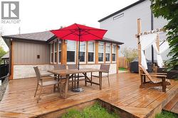 Wooden terrace with a sunroom and outdoor dining space - 