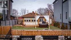 Rear view of house with a wooden deck, a fenced backyard, a hot tub, roof with shingles, and a chimney - 